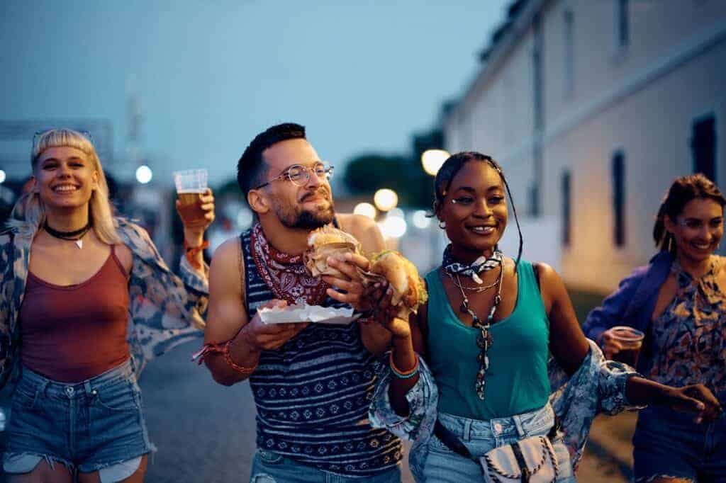 Cheerful group of friends having fun while attending summer music festival.