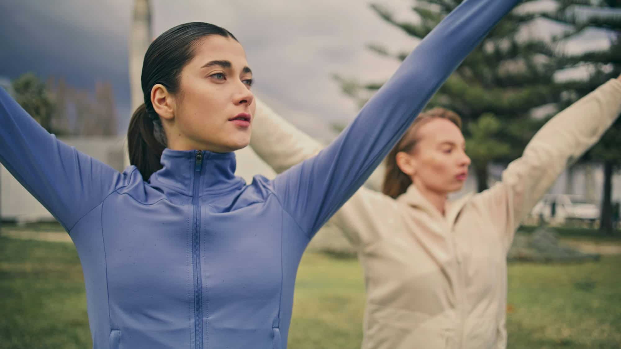 Empowered ladies morning gymnastic routine. Athlete women raising hands training