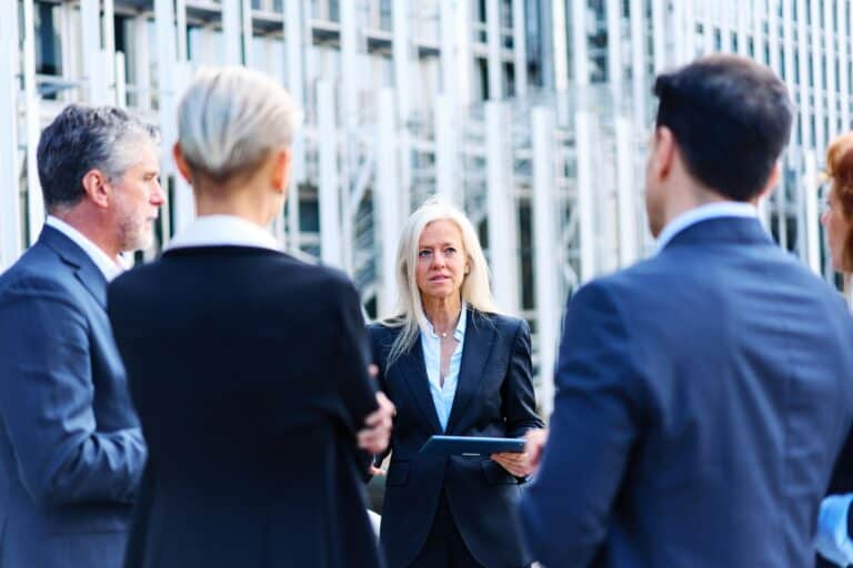 Group of business people talking outside a financial building